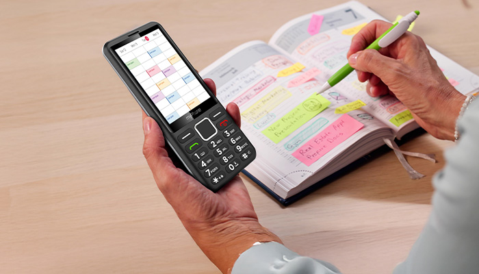 telefon myPhone 3510 LTE w dłoni nad kalendarzem