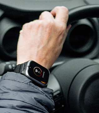 Smartwatch myPhone CareWatch LTE na nadgarstku kierowcy trzymającego kierownicę, z aktywnym ekranem zegarka