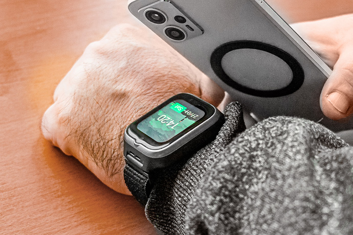 Smartwatch myPhone CareWatch LTE na nadgarstku obok smartfona, z włączonym ekranem zegarka
