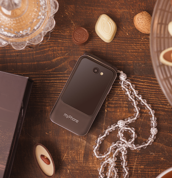 myPhone Harmony LTE Praline Collection  na drewnianym blacie, kryształowy łańcuszek , czezkoladki