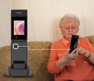 myPhone Tango 2 LTE trzymany przez starszą osobę, siedzącą na kanapie, obok pokazany przycisk SOS na pleckach telefonu