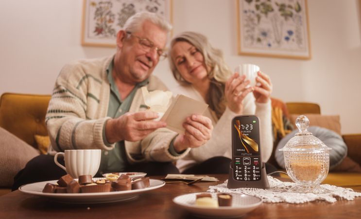 myphone babcia i dziadek przeglądają wspólnie zdjęcia przy herbacie